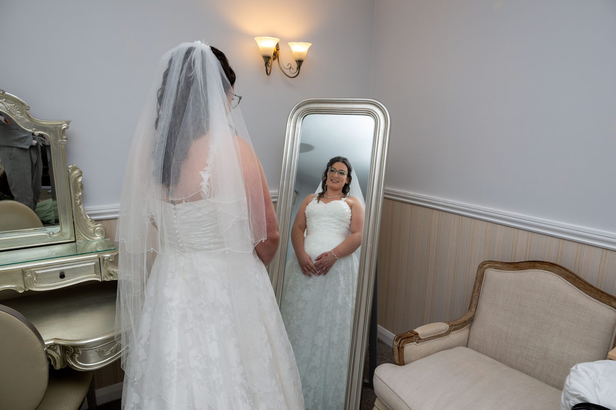 Bride in her wedding dress standing in front of the mirror at Fox & Hounds