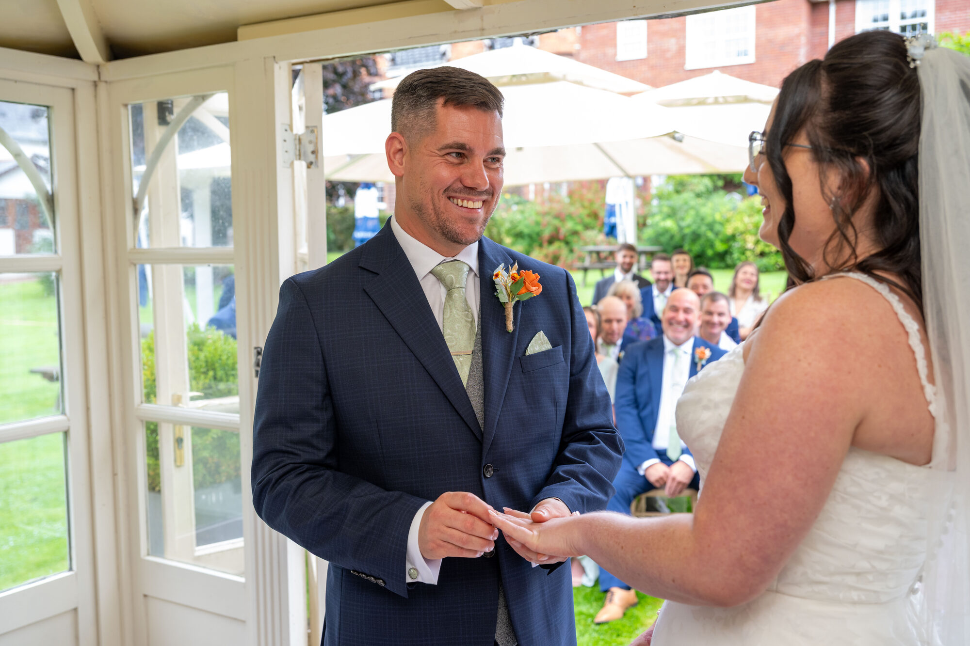 Groom placing the wedding ring on bride's finger during ceremony