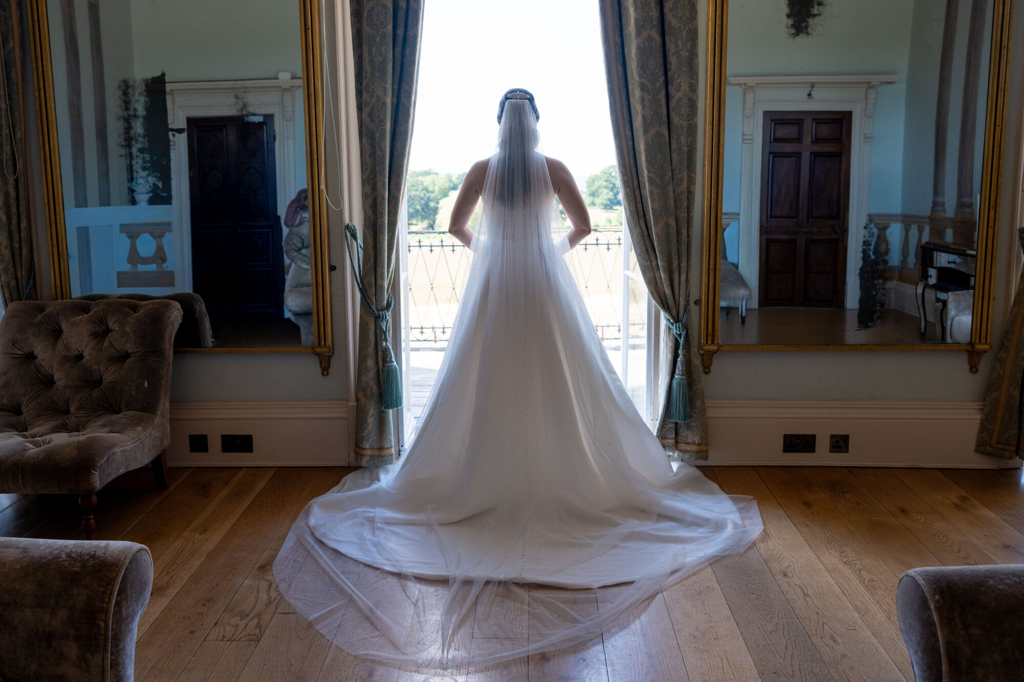 Bride in window light, glowing with the summer sun behind her