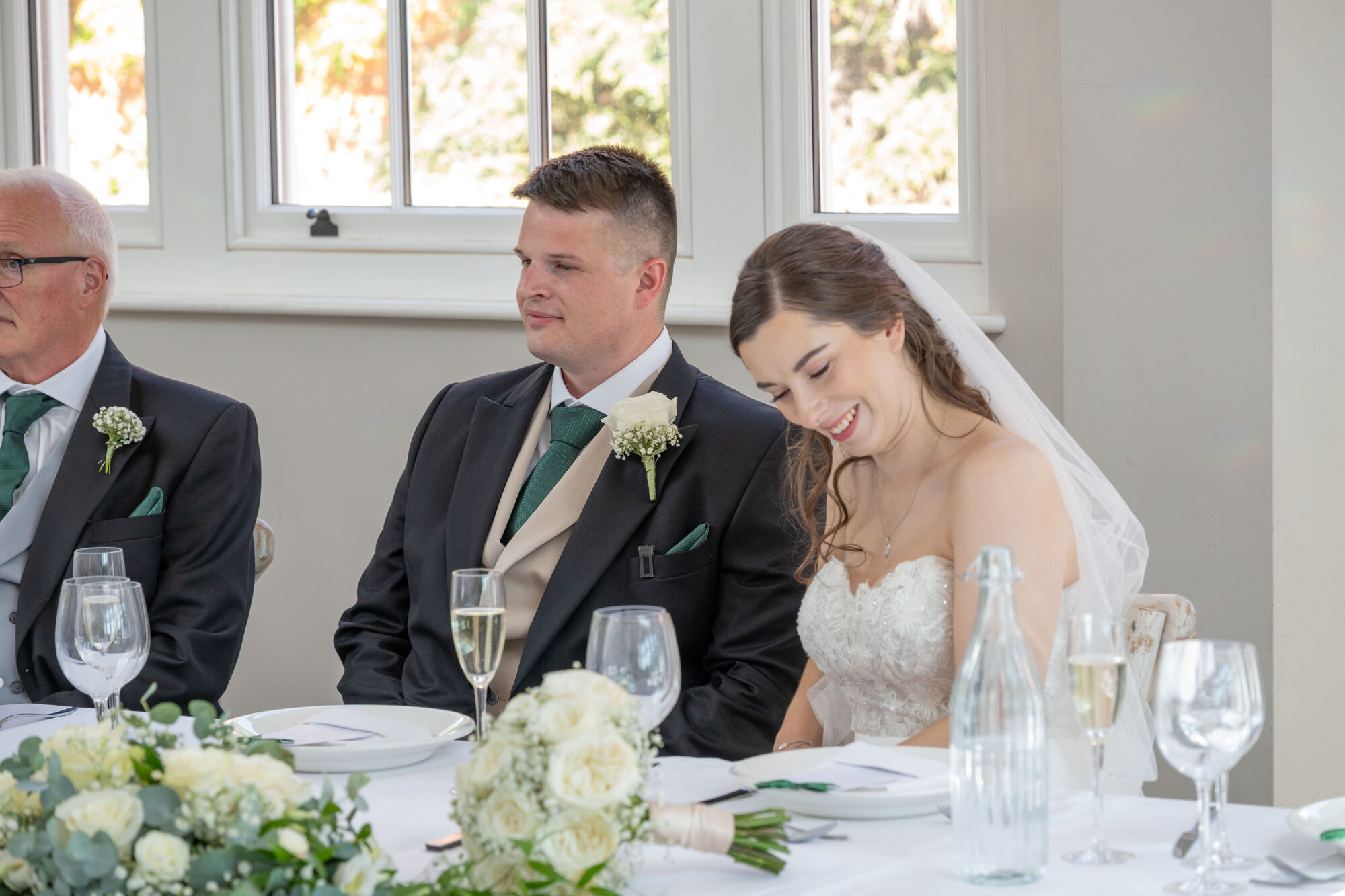 Bride laughing during the wedding speeches at Rockbeare Manor