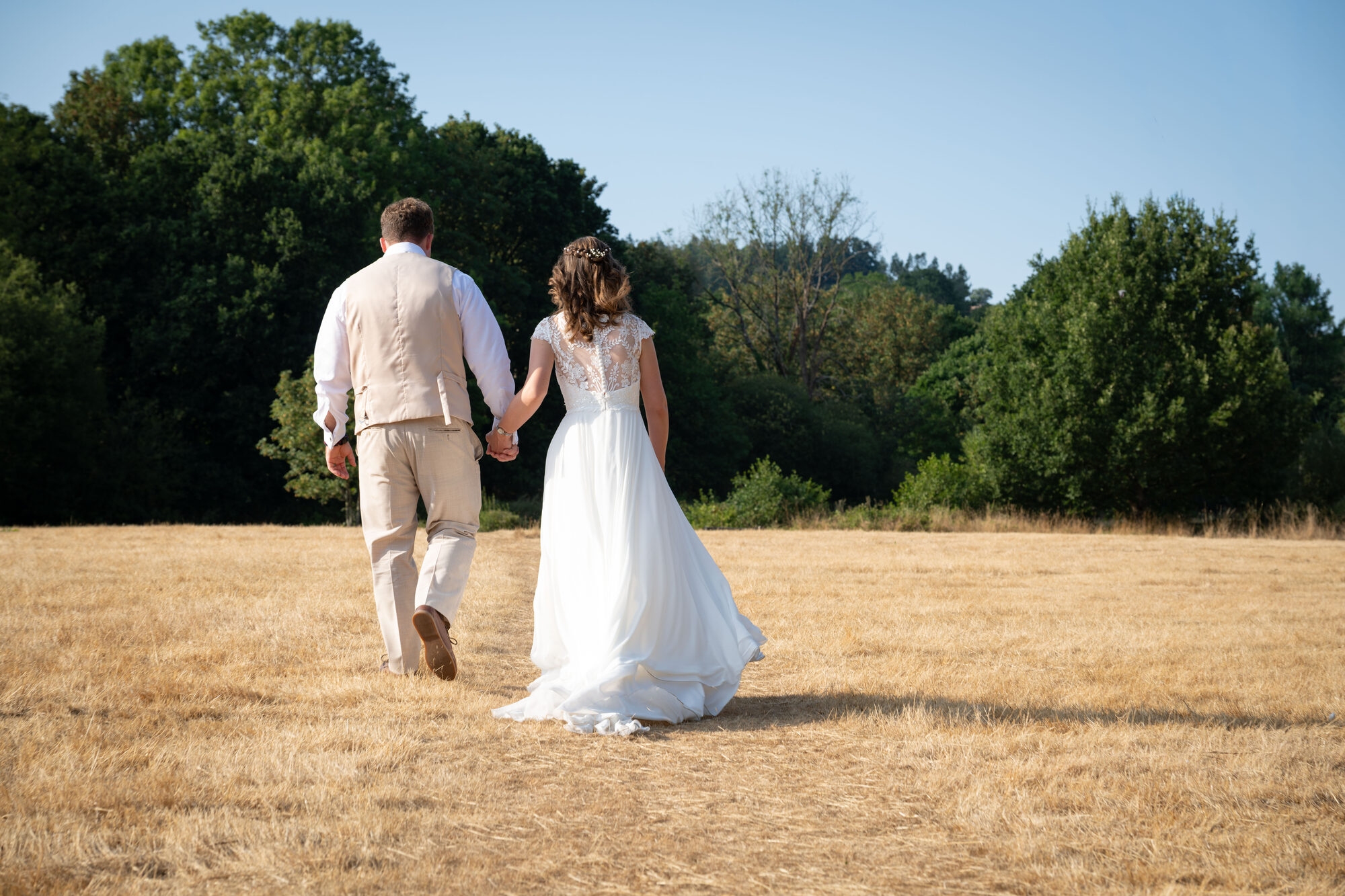 Bride and groom walking towards River Exe for portraits