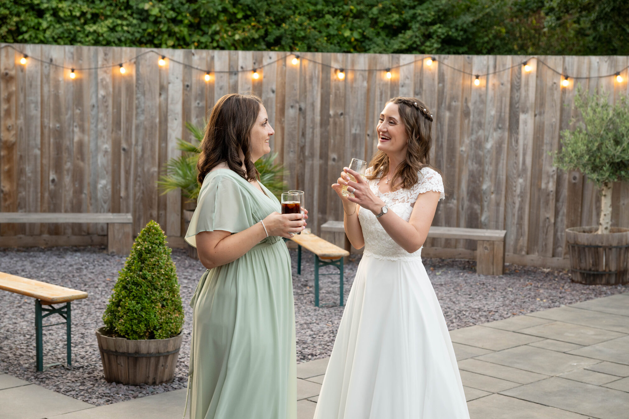 Bride and bridesmaids outside Valleyside Barn at dusk with warm lighting