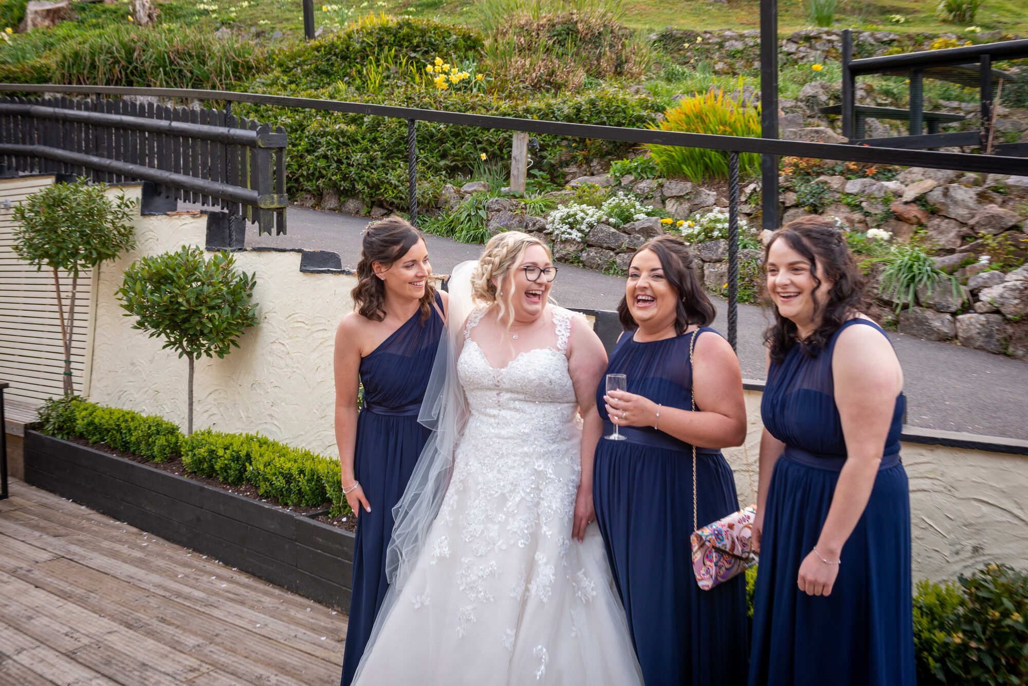 Bride laughing with bridesmaids during wedding morning at Bickley Mill