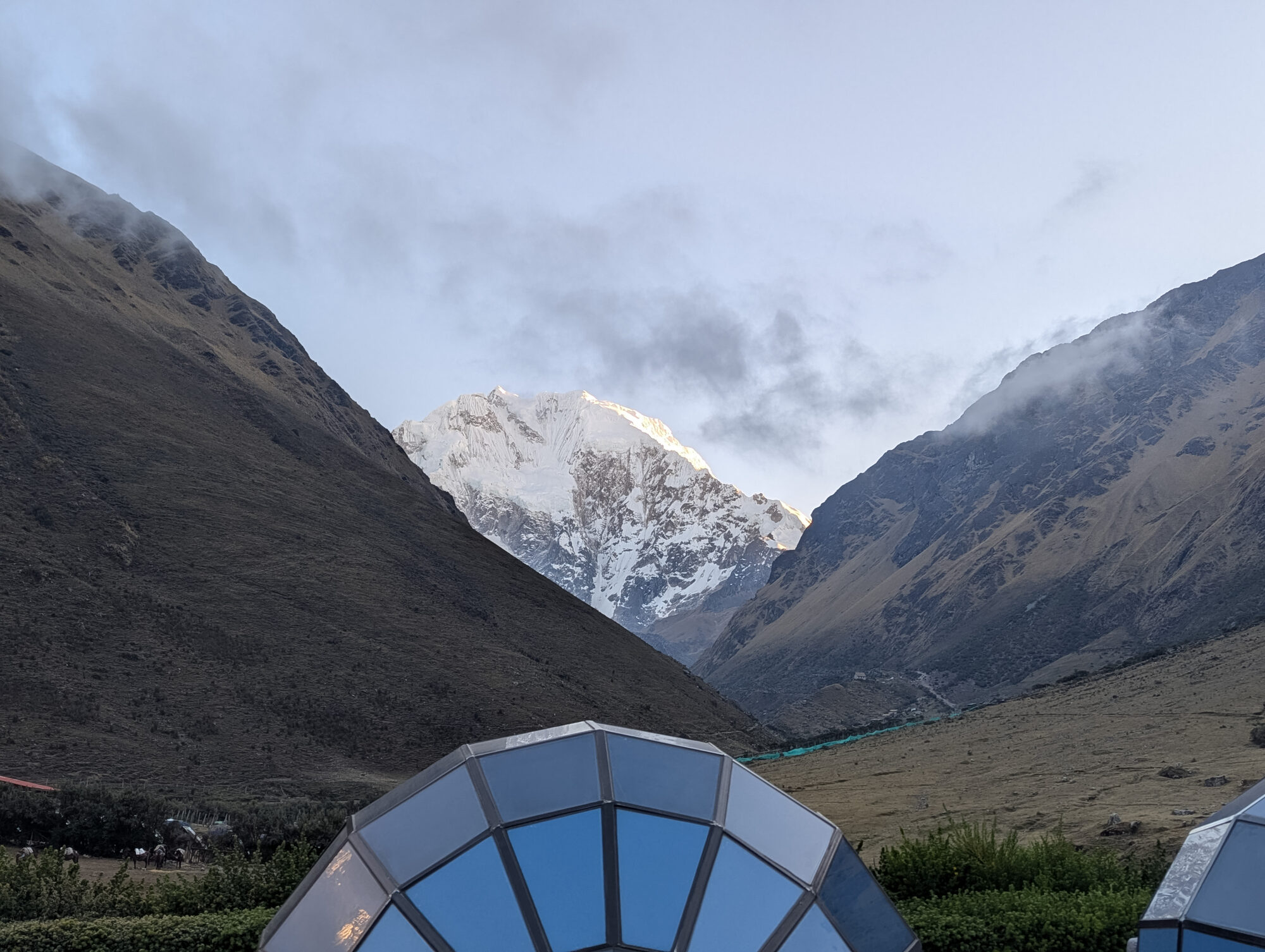 Early morning sunlight illuminating snow-covered mountains on the Salkantay Trek